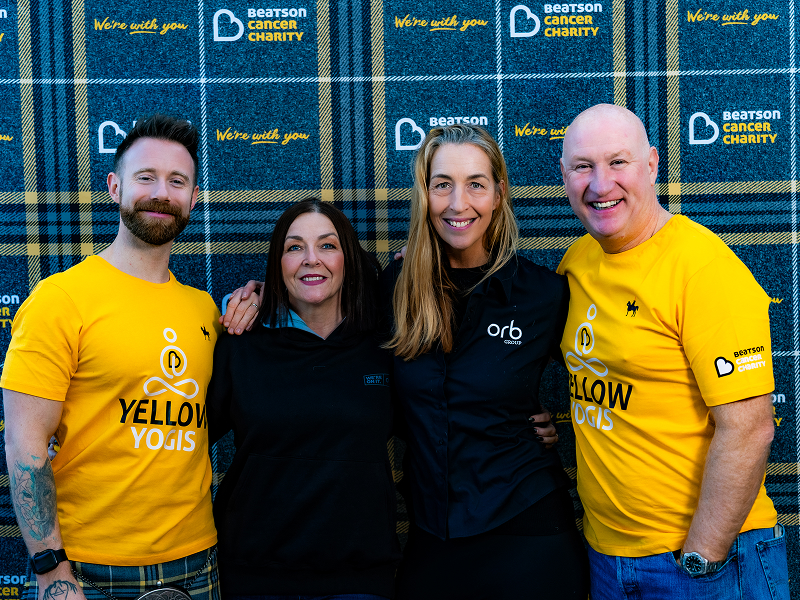Four person group photo infront of a Beatson Cancer Charity backdrop board