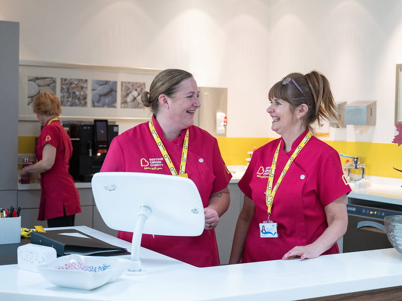 Colleagues of the Beatson Wellbeing Centre smile and converse with eachother